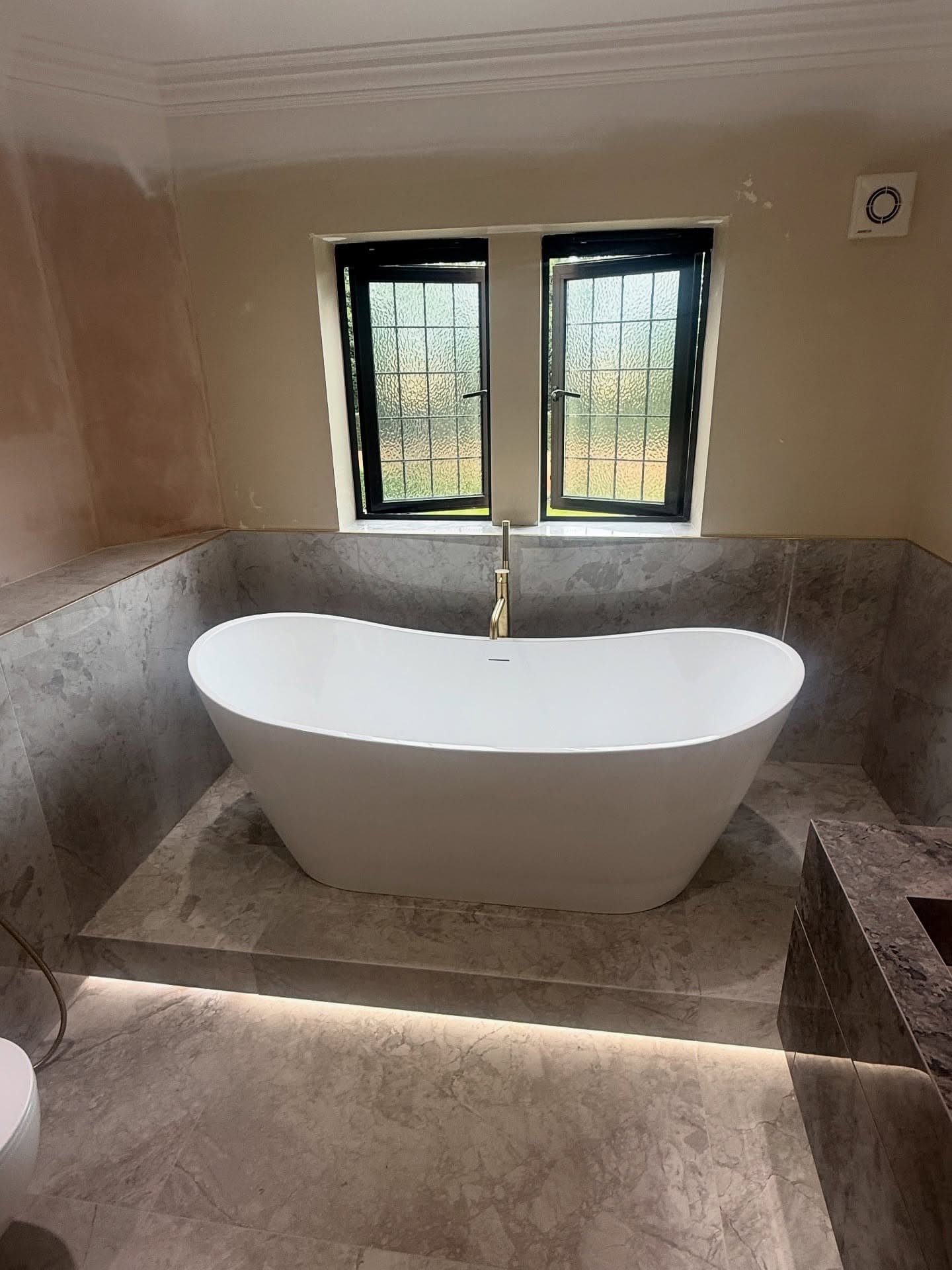 Master bathroom in Sprotbrough with raised bath and brushed brass details