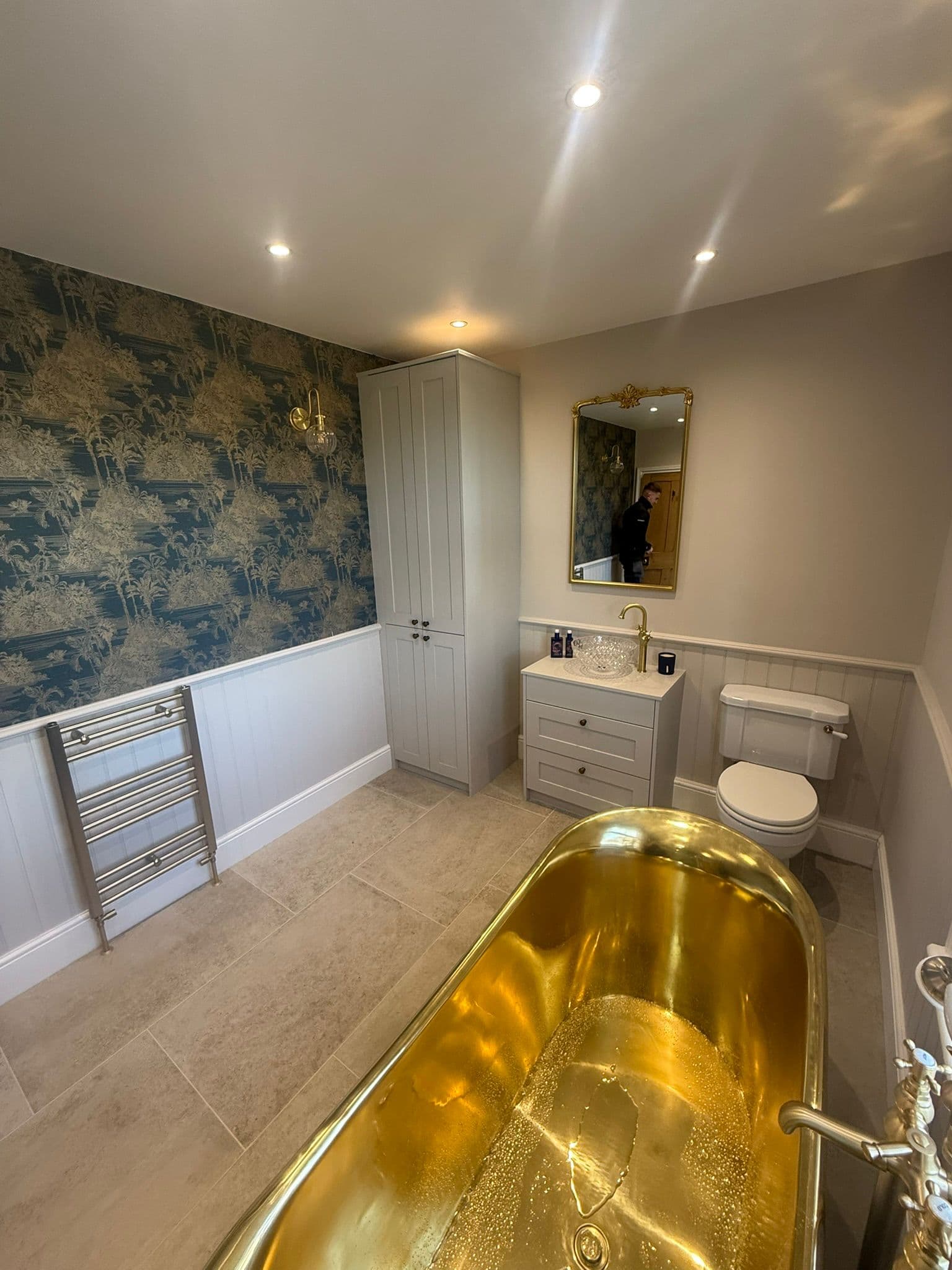 Statement brass bathroom in Ranby with green shower tiling and tiled floor