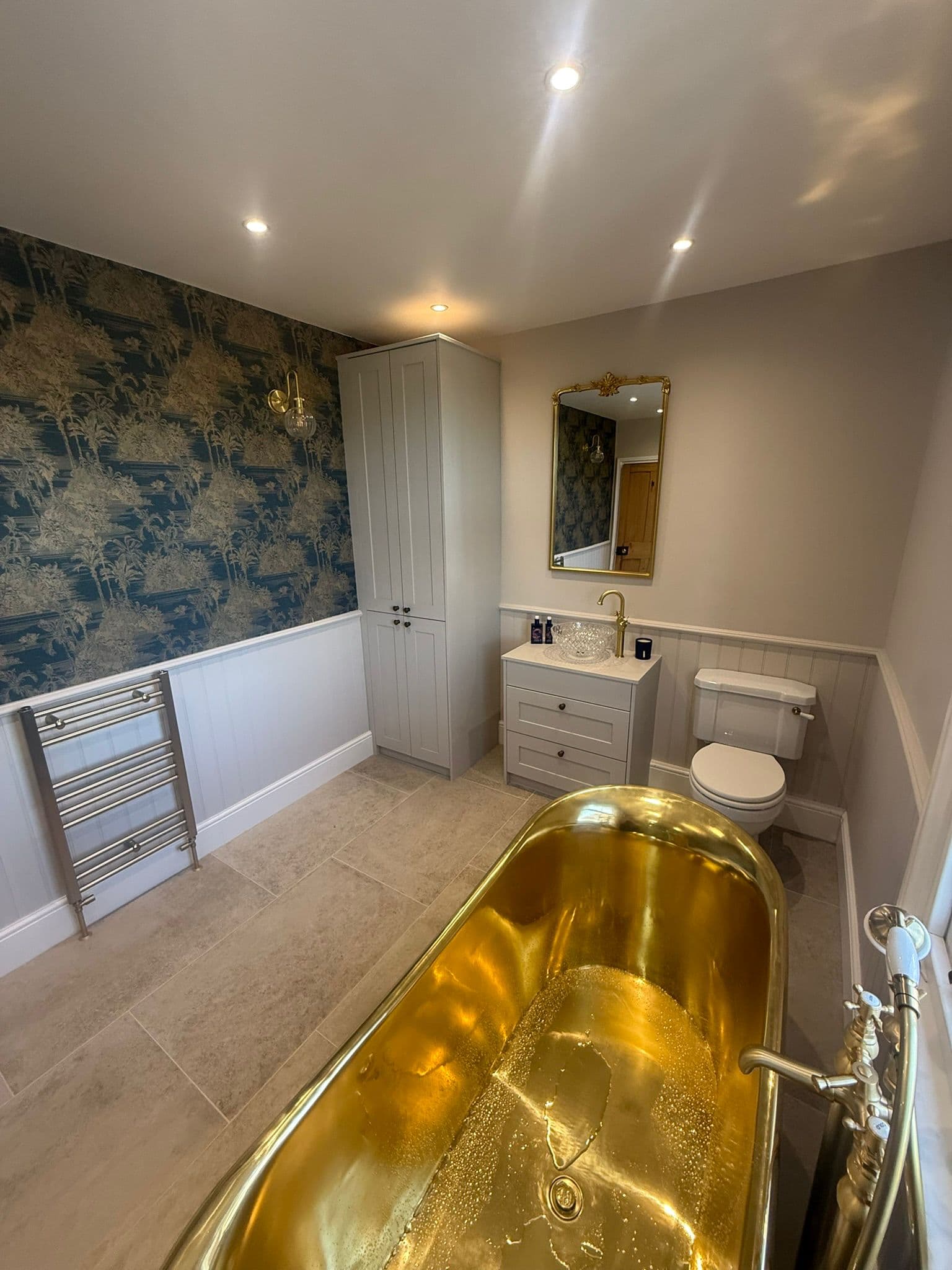 Statement brass bathroom in Ranby with green shower tiling and tiled floor
